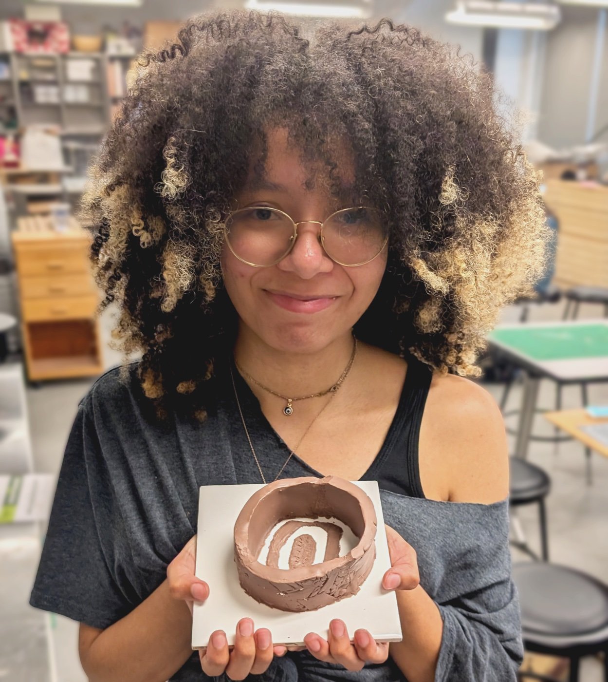 Naomi smiling and holding a freshly cast prosthetic mold in the studio